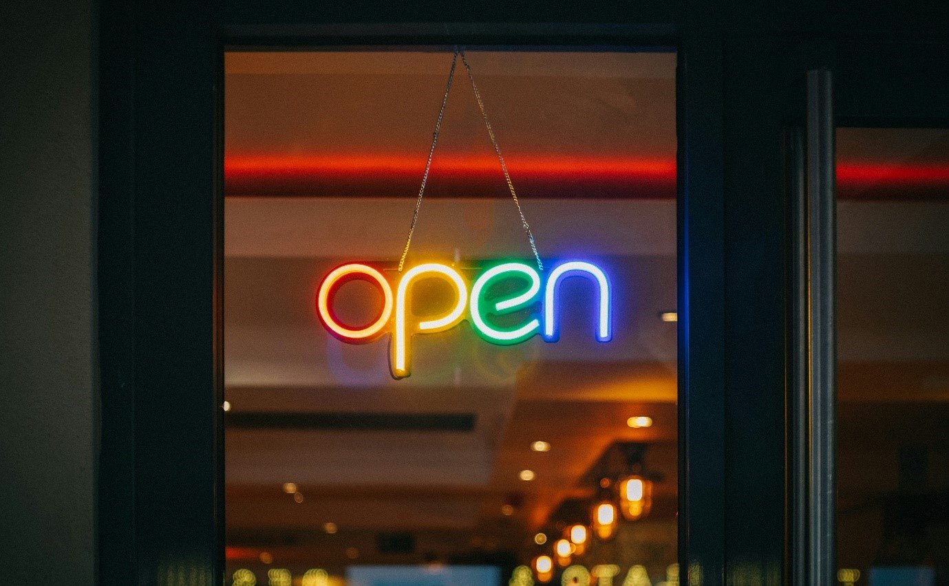 A neon sign in a window

Description automatically generated