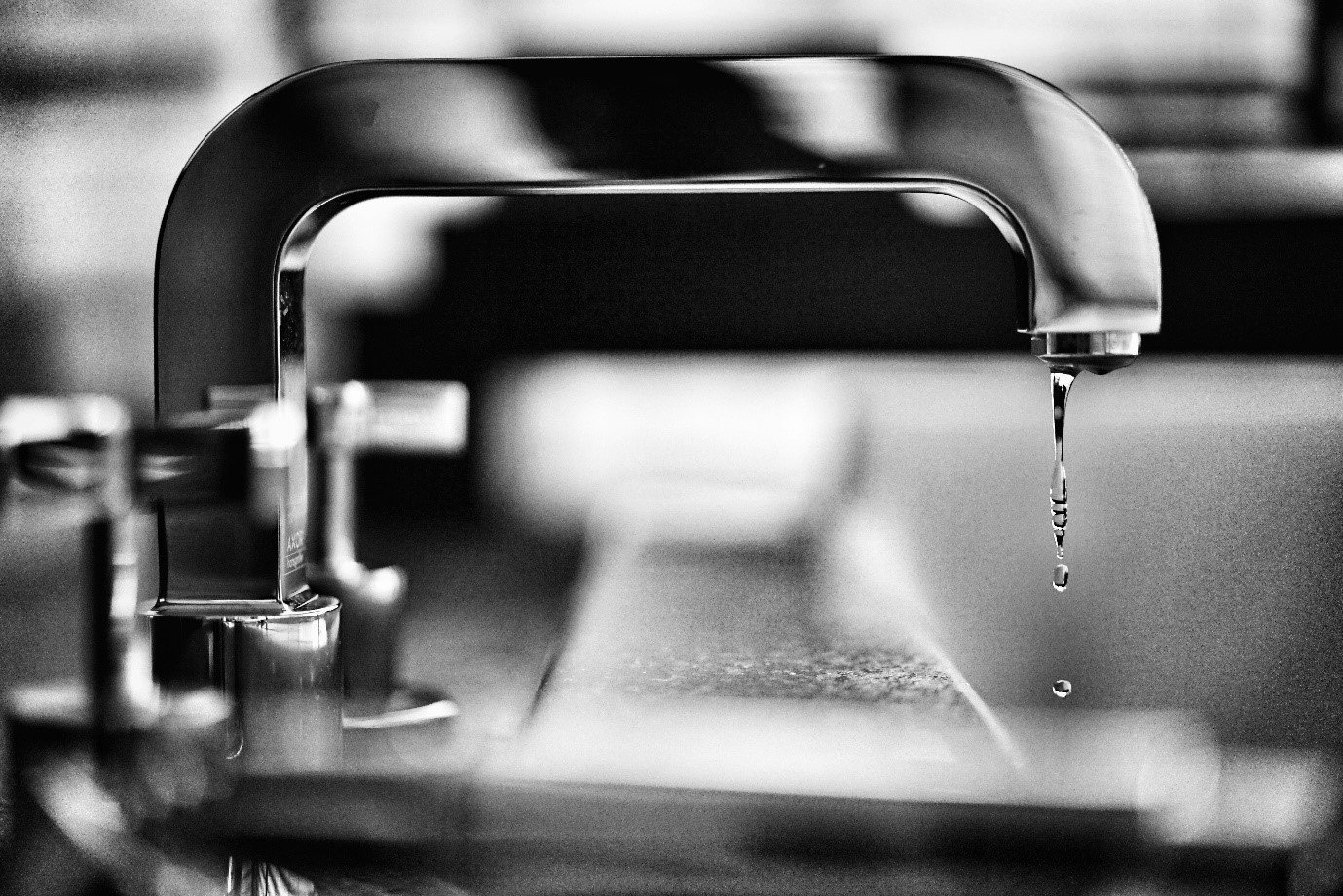 A close-up of a faucet with a drop of water

Description automatically generated