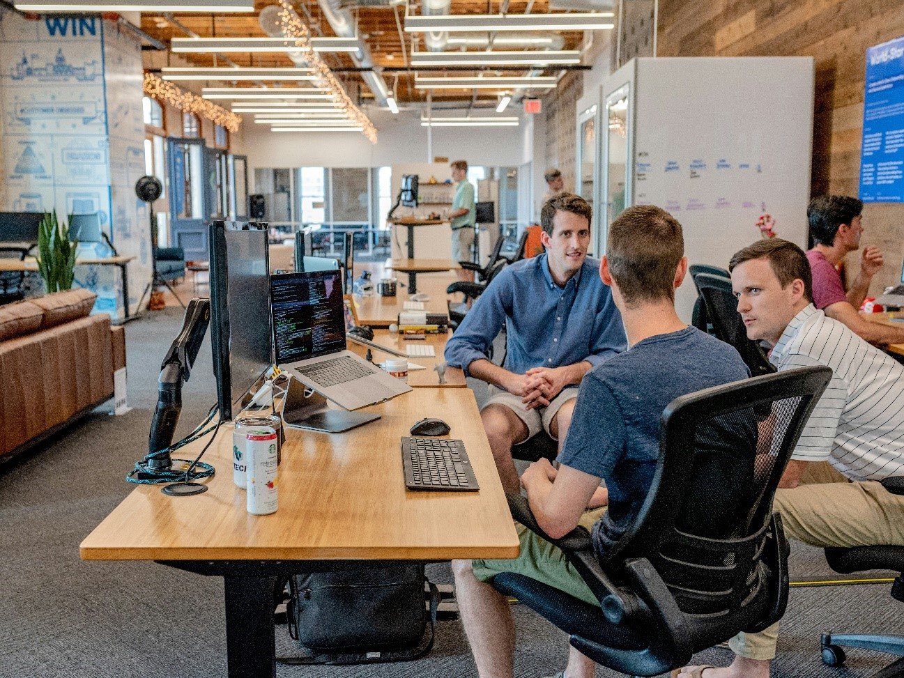 A group of men sitting at a desk

Description automatically generated